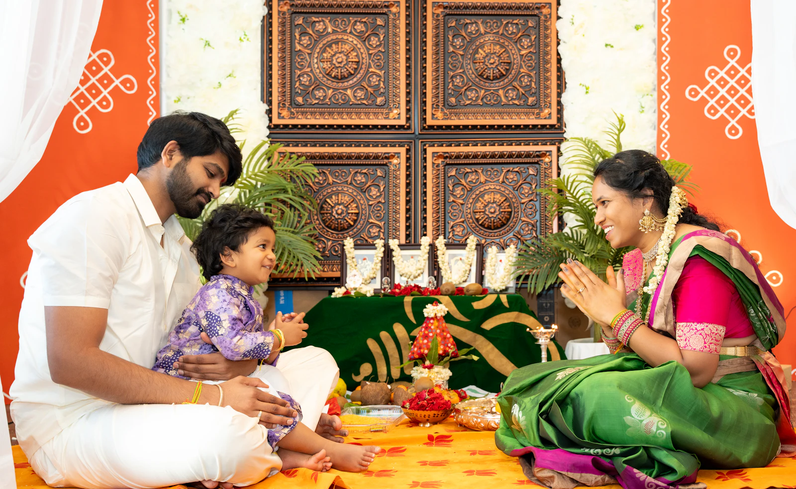 Family performing a puja together in their decorated home