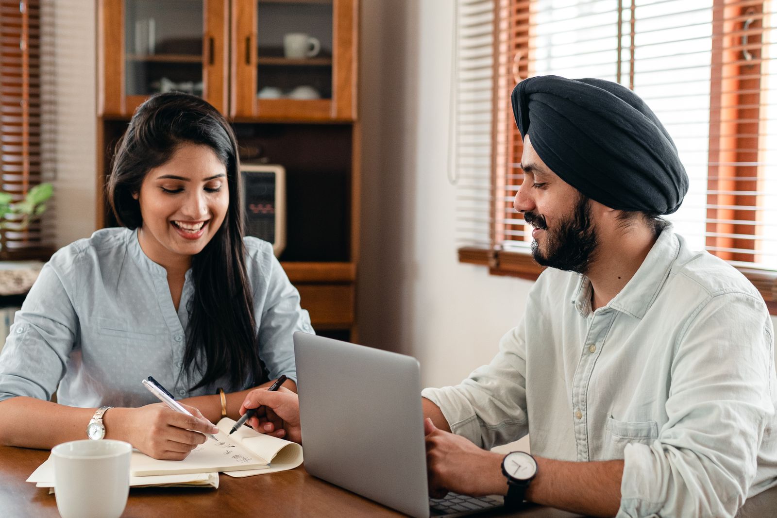 Young Indian couple learning about money on a laptop