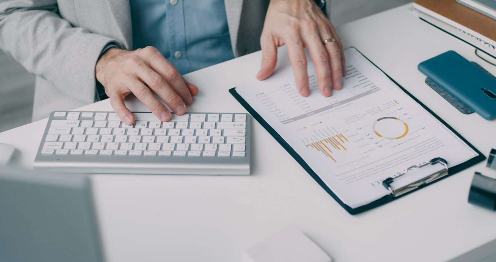 Hands reviewing an investment statement with charts at a desk
